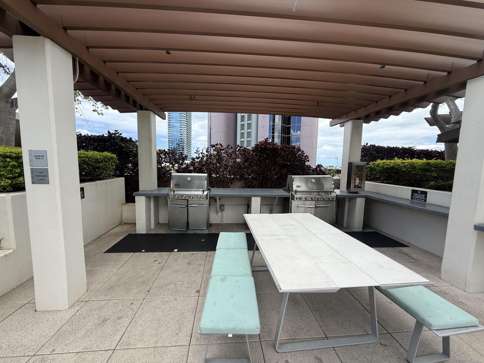 A white table and benches are set up under a covered patio area.